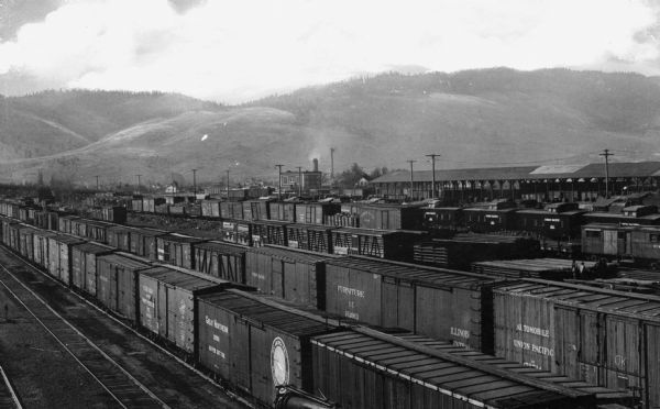 View of several rows of railroad cars at a freight yard.