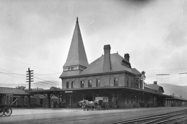 Exterior of North Adams Railroad Station, built in 1871.  A horse-drawn coach can be seen beside the tracks.
