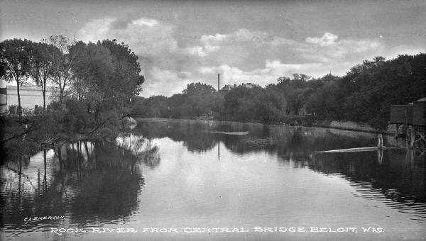 View of Rock River from bridge, featuring Beloit Iron Works factory on the left shoreline. Caption reads: "Rock River from Central Bridge, Beloit, Wis."
