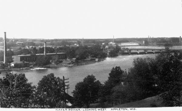 Elevated view of hydroelectric plants on the Fox River. Caption reads: "Water Power - Looking West. Appleton, Wis."