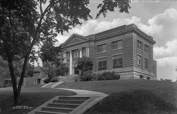 Exterior view of the old Beloit Public Library. There is a bicycle lying on the lawn near the front entrance.
