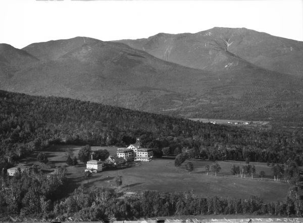 Elevated view of a large hotel located in a broad valley near Mount Lafayette and Cannon Mountain.