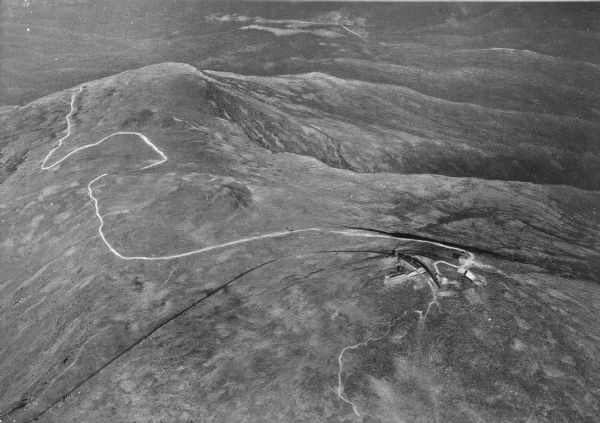 An aerial view of the White Mountains and Mount Washington, including a winding road.