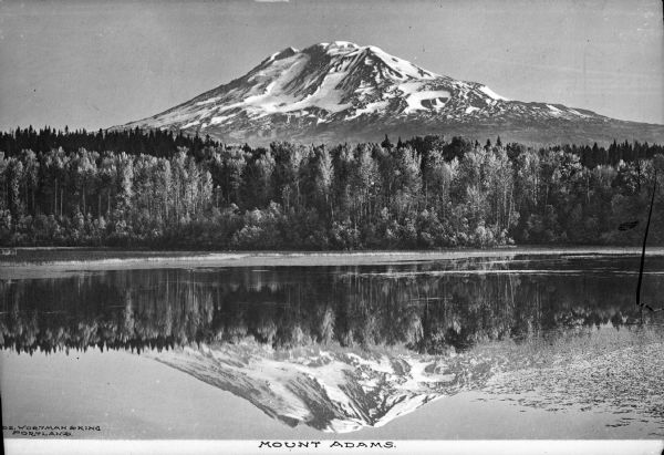 View across water toward Mount Adams, with its snow-capped peak reflected in a lake below. Caption reads: "Mount Adams."