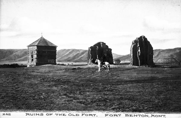 A man on a horse in front of the ruins of the old fort. Caption reads: "Ruins of the Old Fort, Fort Benton, Mont."