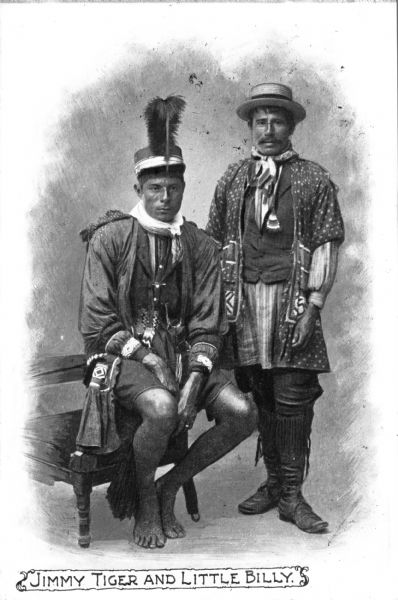 A portrait of Little Billy and Jimmy Tiger, two Seminole Native Americans. Both are wearing hats and intricate native clothing. Caption reads: "Jimmy Tiger and Little Billy."