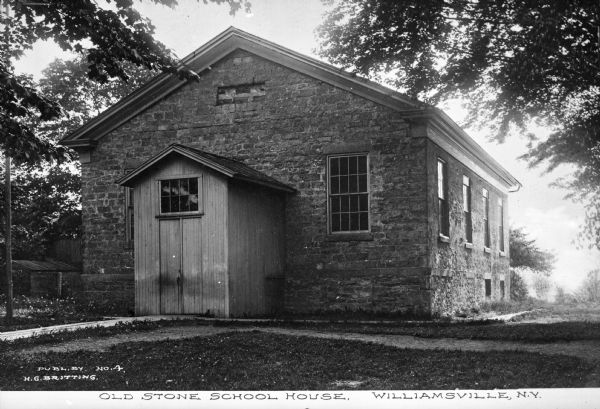 Exterior view of a stone school house, including a covered entrance in front and a sidewalk around the building. Caption reads: "Old Stone School House, Williamsville, N.Y."