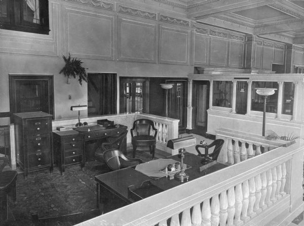 A view of the interior of the Washington Trust Company. A divided area in the foreground has desks and chairs.
