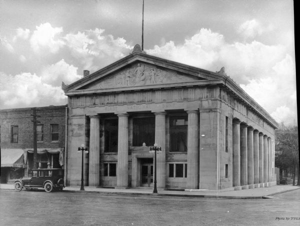 View across street toward the exterior of the First National Bank, a classical stone building.