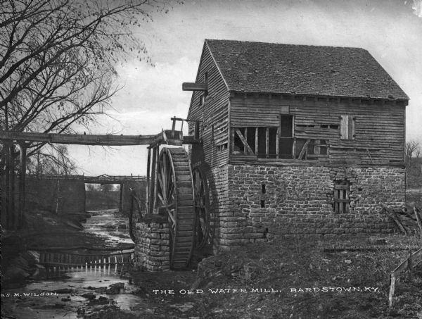 A view of the old water mill, with a bridge over the stream in the background. Caption reads: "The Old Water Mill, Bardstown, KY."