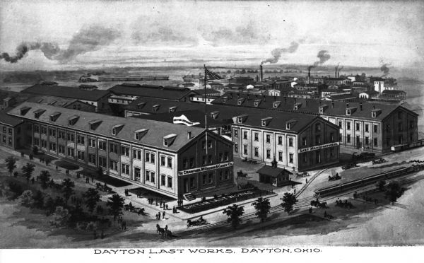 A view of the Crawford, McGregor & Caney Manufacturing Co. with people, horses and wagons, trains, and other buildings visible as well. Text on the photograph reads, "Dayton Last Works, Dayton, Ohio."