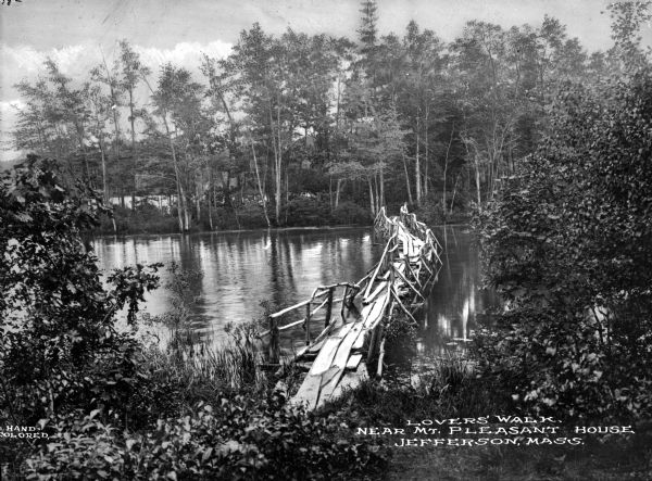 A narrow rustic bridge crossing a pond in a wooded area known as Lovers' Walk. Caption reads: "Lovers' Walk, Near Mt. Pleasant House, Jefferson, Mass."