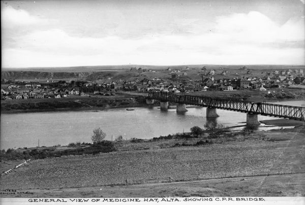 Elevated distant view of the town of Medicine Hat, Alberta and a Canadian Pacific Railway Bridge. Caption reads: "General View of Medicine Hat, Alta. Showing C.P.R. Bridge."
