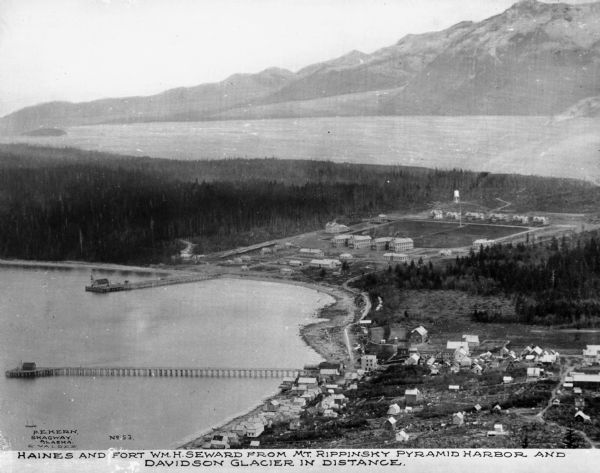 Elevated view of Fort Seward from Mount Rippinsky, showing Pyramid Harbor and Davidson Glacier in distance. Caption reads: "Haines and Fort Wm. H. Seward from Mt. Rippinsky Pyramid Harbor and Davidson Glacier in Distance."