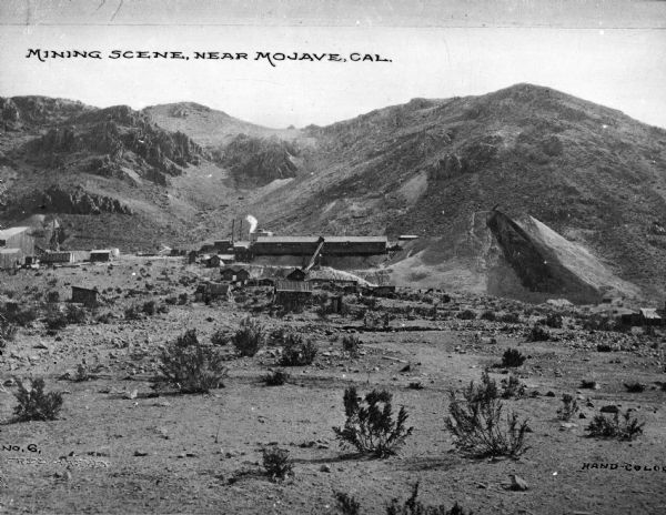 Distant view of a mining operation and surrounding desert hills. Caption reads: "Mining Scene, Near Mojave, Cal."