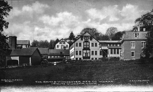 View from across a lawn of Smith and Winchester Manufacturing Company buildings, producers of paper making machinery and laundry equipment. Caption reads: "The Smith & Winchester M'F'G Co. Works, South Windham, Conn."