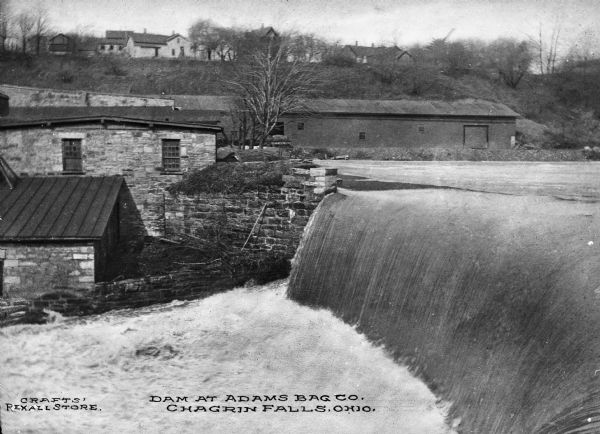 Dam on the Chagrin river near Adams Bag Company with buildings in background. Caption reads: "Dam at Adams Bag Co. Chagrin Falls, Ohio."
