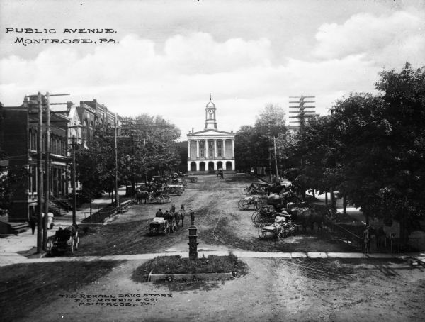 View of Public Avenue leading up to the Susquetanna County Court House and lined with horse-drawn carriages. Caption reads: "Public Avenue, Montrose, PA."