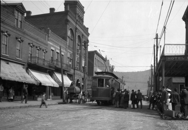 Street scene with people entering a cable car on Hanover Street.