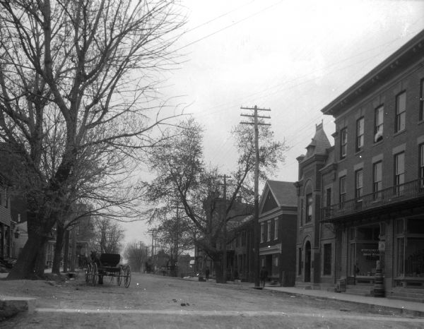 View down Main Street with a horse-drawn carriage and large brick buildings.