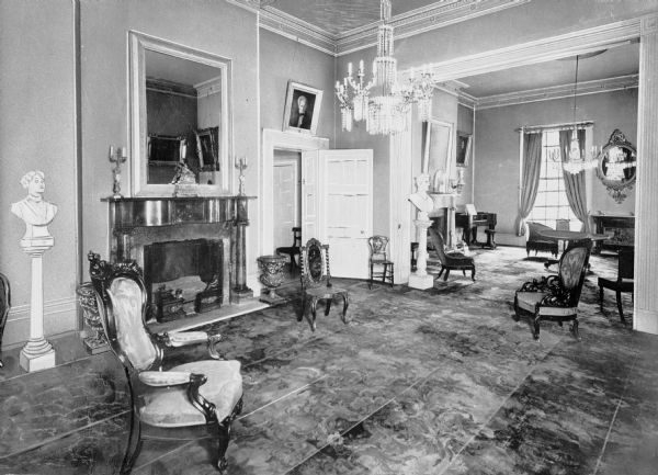 Interior view of a drawing room in the Hermitage, home of Andrew Jackson, featuring chandeliers, a harpsichord and ornately carved furniture.