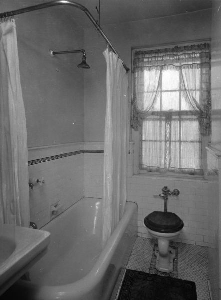 View of a bathroom in the Amalgamated Clothing Workers Cooperative Apartments. Features porcelain bathtub, sink, and toilet.