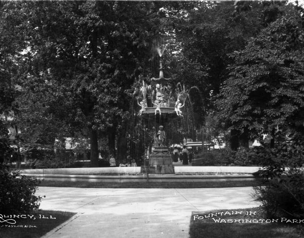 Fountain in Washington Park with women and children in background.  Caption reads: "Fountain in Washington Park."