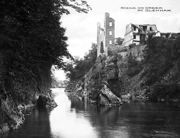 Water-level view of a brick building's ruins on a cliff overlooking Fishkill creek. Caption reads, "Scene on Creek at Glenham."
