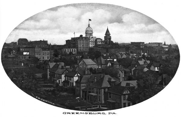 Elevated view of the town with the Westmoreland County Courthouse centered in the background. The town has densely built large houses and tall buildings. Caption reads, "Greensburg, PA."
