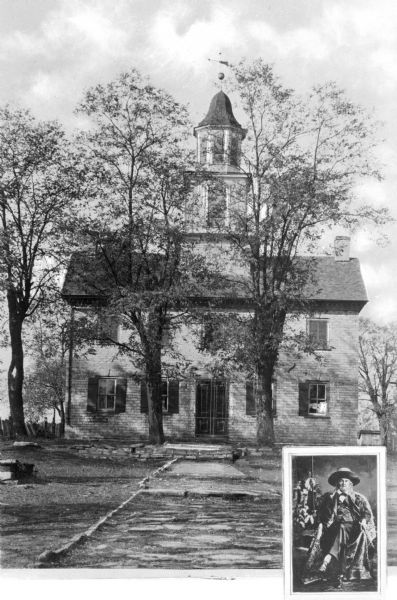 A textbook print of the facade of the Old Stone Courthouse, taken from the path leading up to the building. There is also an inset image of an unidentified man in the bottom right corner.