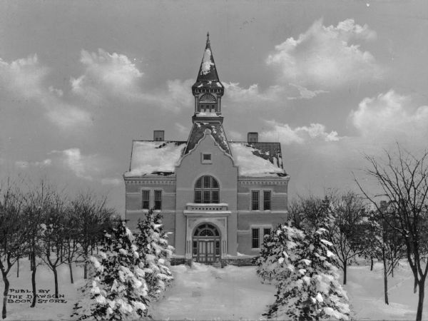 Exterior view of the spired courthouse after a snowfall, from a tree-lined path.