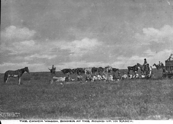 View across field toward ranch hands having dinner at the chuckwagon. A dozen or so men are sitting on the ground, while a few other ranch hands mind the cattle. A horse stands to the left of the scene, and the wagon sits to the right. Caption reads: "The Chuck Wagon, Dinner at the Round-Up, 101 Ranch."

In 1975, the ranch was designated as a National Historic Landmark.  

A chuckwagon was originally a wagon that carried food  and cooking  equipment on the prairies of the United States and Canada. The invention of the chuckwagon is attributed to Charles Goodnight, a Texas rancher who introduced the concept in 1866.