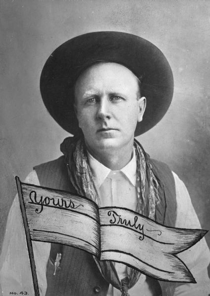 Postcard of a portrait of a cowboy, with a super-imposed pennant that reads: "Yours Truly ~" with a blank line underneath. The man is wearing a hat, shirt with vest, and neckerchief.