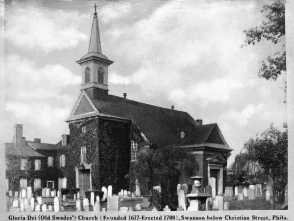 View across cemetery toward the church, which has vines growing on the walls. Caption read: "Gloria Dei (Old Swedes') Church (Founded 1677-Erected 1700), Swanson below Christian Street, Phila."