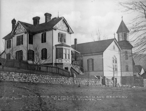 View uphill toward the church and refectory. The refectory is on the left. A stone wall is at the base of the hill. Caption reads: "St. Joseph's Catholic Church and Refectory. Clifton Forge, VA."