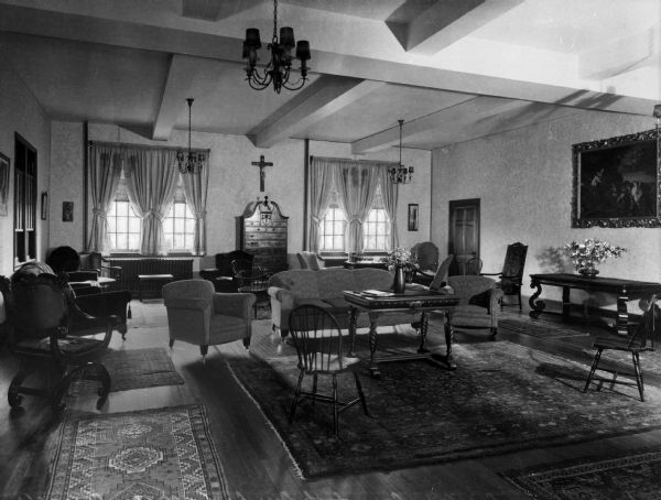 Interior view of the lounge at the Our Lady of the Cenacle convent. The room is furnished with upholstered chairs and couches, tables, and area rugs.