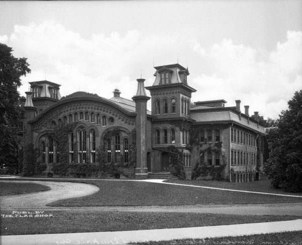 View across lawn toward the campus art museum. Large arched windows run along the facade, and the main entrance is nestled into a corner tower. The brickwork contains many decorative elements, most notably above the windows.