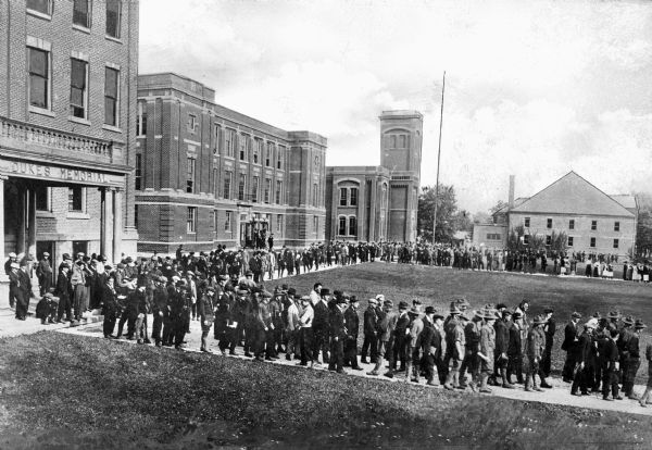 A group of students walks around the quadrangle at Ohio Northern University. The text on the building to the left reads: "Dukes Memorial."