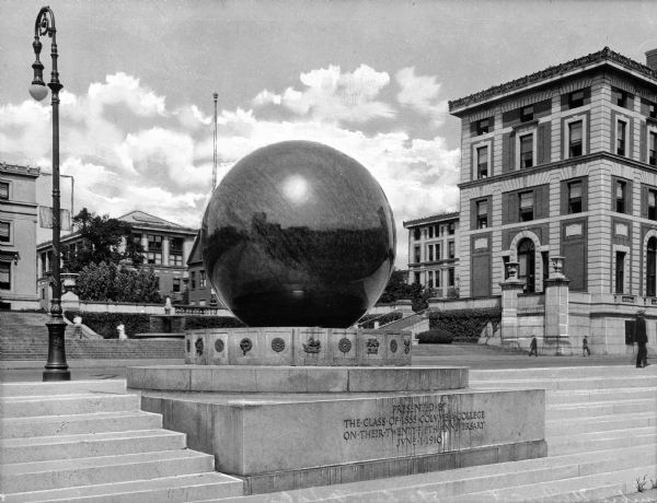 A view of the campus sundial, which sits in a spacious outdoor area. Its main parts include a large stone sphere and stone base.