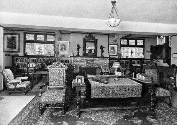 A view of the living room at the Switzer Foundation for Girls. Bookshelves flank the fireplace in the background, and groupings of chairs and tables fill the rest of the room.