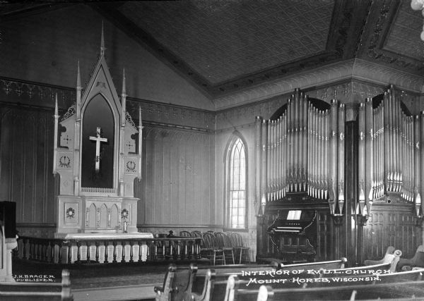View towrd the altar and pipe organ at Evangelical United Lutheran Church. The walls and ceiling of the church are decorated with interlocking pointed arches and quatrefoils, hallmarks of Gothic Revival style.