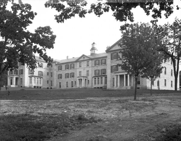 View across lawn toward the Wright, Evans, and Shaler Halls at Ripon College. The building is made out of stone, and a porch with columns protects each doorway.