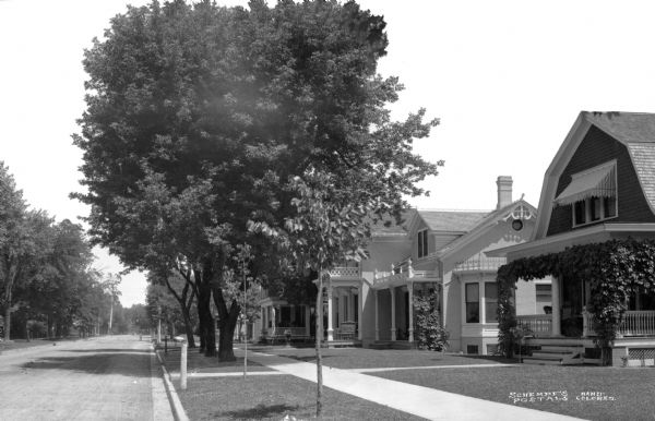 View along right side curb toward houses along the right side of tree-lined Washington Street.