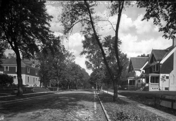 View along right side curb along Fourth Street, with houses on both sides.