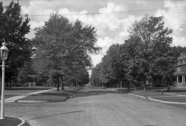 View down Clyman Street at an intersection. A lamppost in on the left corner in the foreground. Trees are planted between the terrace and sidewalk.