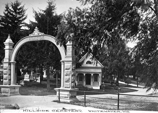 View of the gate and gatehouse at Hillside cemetery. Caption reads: "Hillside Cemetery, Whitewater, Wis."