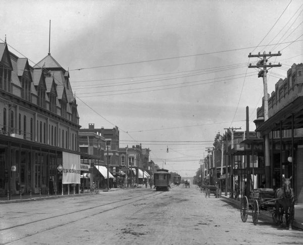 View of Allen Street looking north. Streetcars are in the center of the street, and horse-drawn carts are parked on the right side of the street.