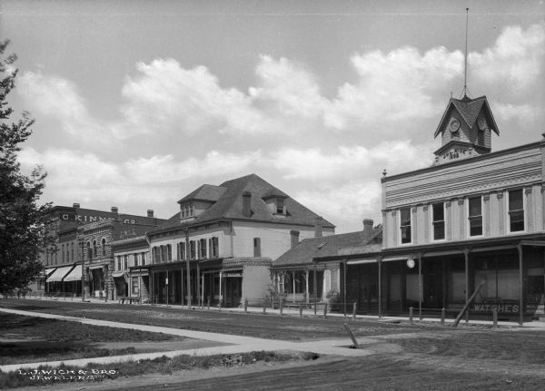 The Main Street shopping district. Sign on building on far right reads: "Jul. Wick 1892." The business on far left is "C. Kinne & Co."
