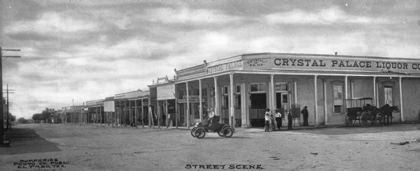 Business signs read: "Crystal Palace Liquor Co.," "Rock & Christy" and "Headquarters Saloon" (partially obscured). Writing on photograph reads: "Humphries Photo Co. Publ. El Paso, Tex." and "Street Scene."