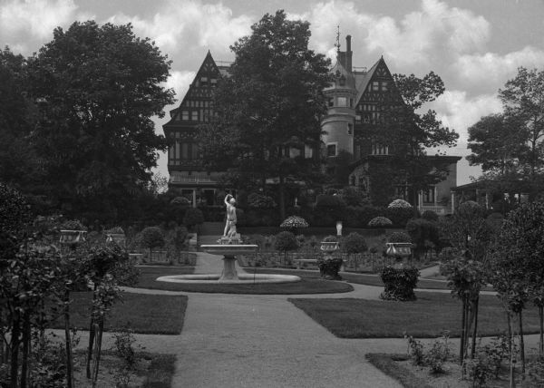 The residence and gardens of Mr. and Mrs. Richard Mortimer. View of mansion, gardens, and fountain.